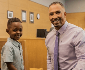 Photo of a man working with a child in a courtroom